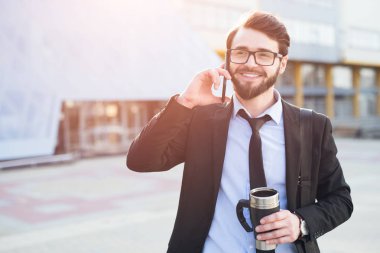 Modern iş adamı elinde kahve ile Smartphone cep telefonu ile konuşmak