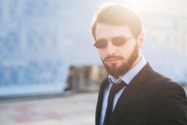 Gökdelen arka plan üzerinde sakallı hippi portresi.