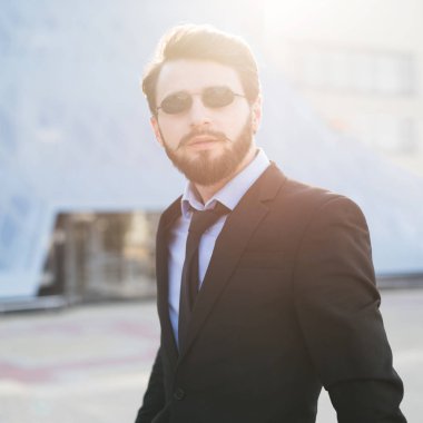 Gökdelen arka plan üzerinde sakallı hippi portresi.