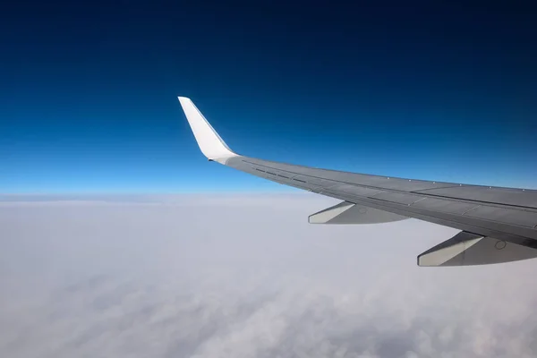 El ala de un avión en un cielo puro de día. Entre el cielo y la tierra . —  Fotos de Stock