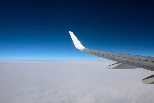 De vleugel van een vliegtuig in de lucht van een zuivere dag. Tussen hemel en aarde. — Stockfoto