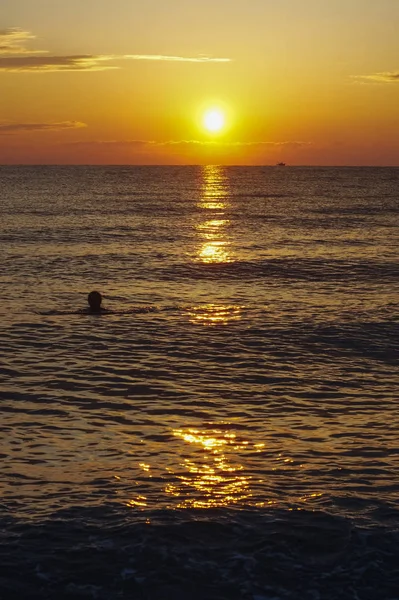 Zwemmen vrouw genieten van de zonsopgang van de Egeïsche zee. — Stockfoto