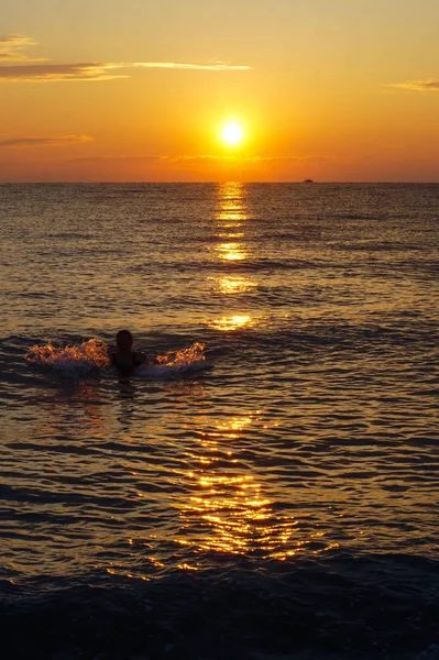 Zwemmen vrouw genieten van de zonsopgang van de Egeïsche zee. — Stockfoto