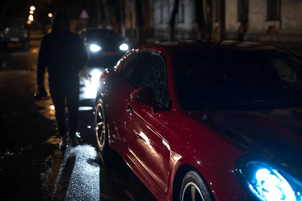 Moderno auto rojo cerca de humanos. Concepto dramático . — Foto de Stock