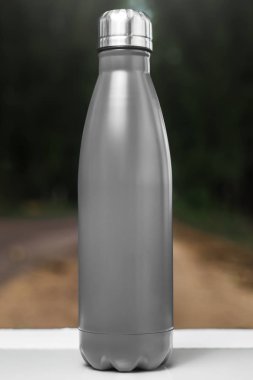 Paslanmaz termos su şişe beyaz masada açık. Siyah renk