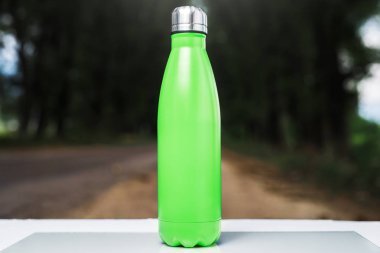 Paslanmaz termos su şişe beyaz masada açık. Açık yeşil renk