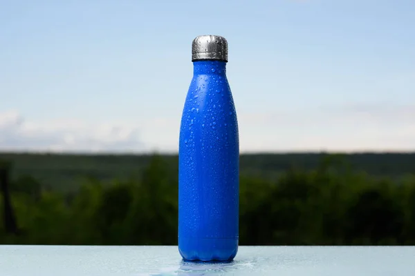 Botella Termo Inoxidable Rociada Con Agua Cielo Bosque Fondo Escritorio — Foto de Stock