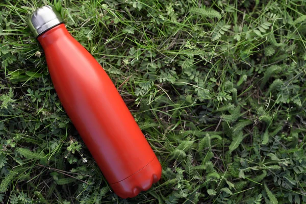 Butelka Stali Nierdzewnej Termos Czerwony Kolor Tle Zielonej Trawie — Zdjęcie stockowe