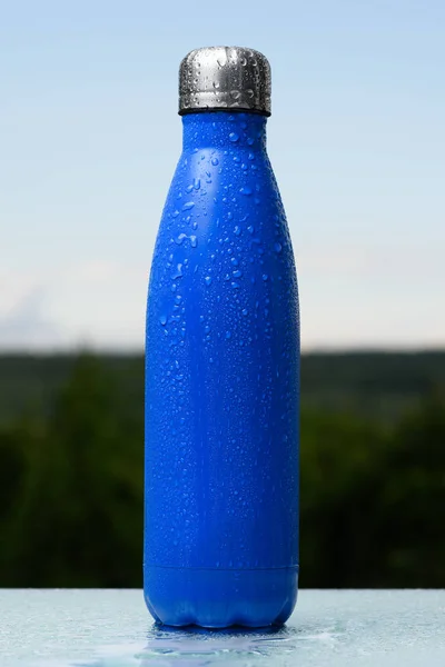 Botella Termo Inoxidable Rociada Con Agua Cielo Bosque Fondo Escritorio — Foto de Stock