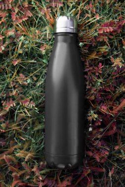 Paslanmaz şişe termosu, siyah renk. Yeşil çim zemin üzerine