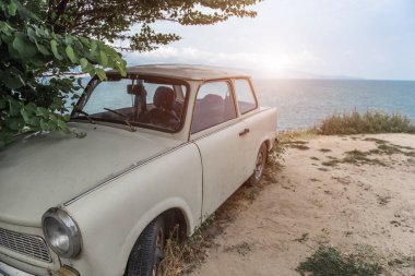 Terk edilmiş eski model Avrupa araba deniz kıyısında.