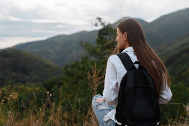 Dağlar çerçevede bir sırt çantası ile genç kız