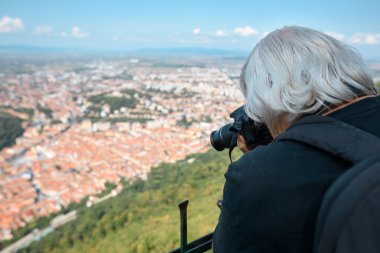 Yaşlı adam profesyonel kamera fotoğraf çeker. Transilvanya, Romanya, Braşov - 2017