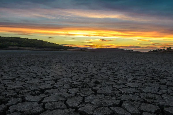 夕日を背景に 池を乾燥した後 泥を乾燥します — ストック写真