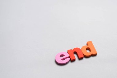 Sonunda, renkli polistren harflerle beyaz arka plan üzerinde yazılı kelime