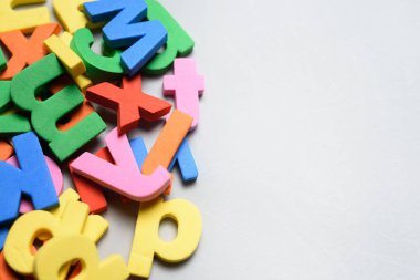Beyaz bir arka plan üzerinde renkli harfler oyuncaklar