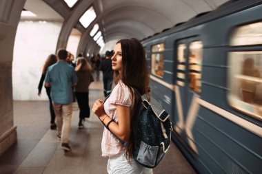 Metro ile geri harekete hazır çantalı kız