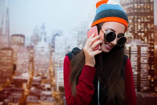 Молодая Позитивная Девушка Солнечных Очках Разговаривает Телефону Своей Комнате Фоне — стоковое фото