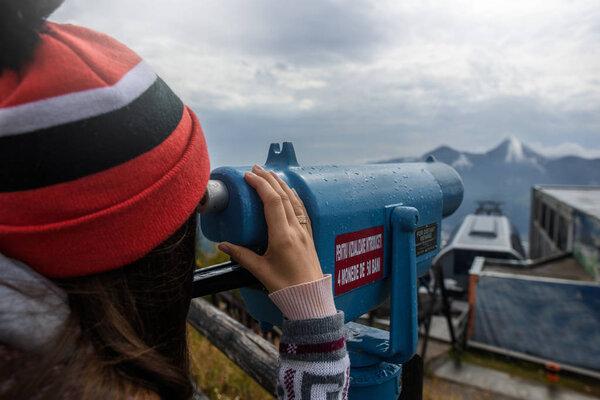 Young girl looks through binoculars on a mountain with a viewing platform. Part 2..