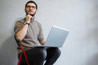 Beyaz arka plan üzerinde dizüstü bilgisayar kullanarak hipster genç düşünme sakallı