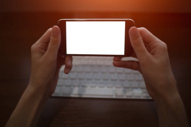 Kadın eller klavye arka plan üzerinde boş mockup ile smartphone kullanarak yakın çekim görüntüsü