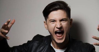 Duygusal çığlık atan genç adam, arka plan gri portresi