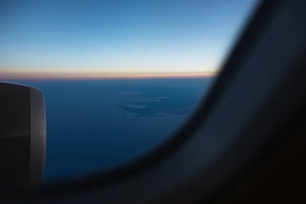 窓から空港の滑走路に飛行機エンジンを見る 日の出に 空の上 — ストック写真