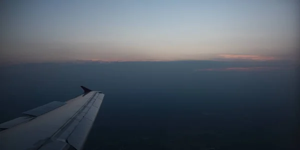 Вид з вікна на крило літака, над небом, на схід сонця . — стокове фото