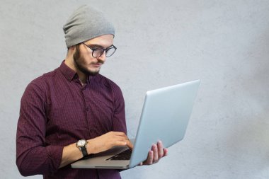 Genç Genç adam beyaz stüdyo arka plan üzerinde dizüstü bilgisayar kullanarak.