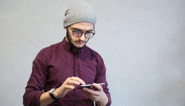 Beyaz arka plan üzerinde smartphone kullanarak hipster Genç sakallı