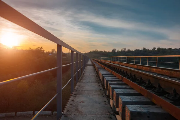 Landskap av järnvägsspår över bakgrunden av färgsprakande solnedgång. — Stockfoto