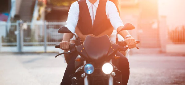 Joven pareja ridind motocicleta al atardecer en la ciudad . —  Fotos de Stock