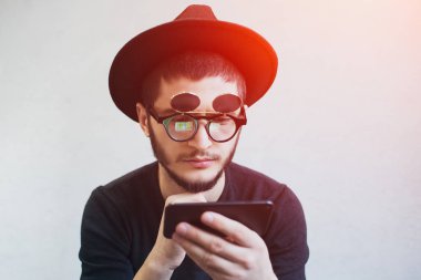 Hipster portresi smarphone beyaz arka plan üzerinde kullanan adam sakallı