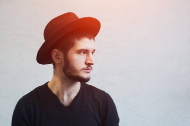 Siyah şapkalı yakışıklı sakallı hippi adam portresi.