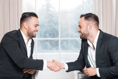 Mutlu işadamları tokalaşırken toplantıda penceresinin arka plan üzerinde