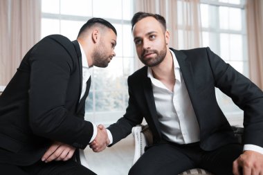 Tokalaşırken toplantıda penceresinin arka plan üzerinde iş adamları. Takım elbiseli giyinmiş