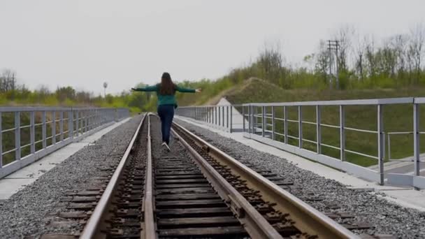Joyeux adolescent fille courir sur le chemin de fer . — Video