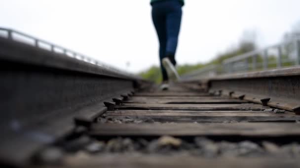 Las piernas de la chica corriendo en el ferrocarril . — Vídeo de stock