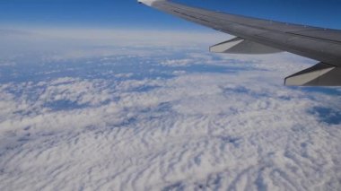 Uçak kanadı uçak penceresinden görünümü. Bulutların üstünde uçan.