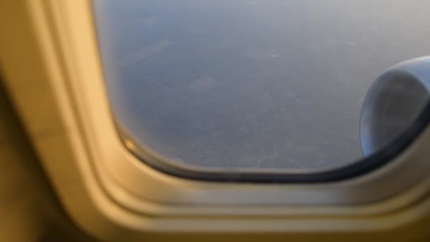 Vue de l'aile de l'avion par la fenêtre de l'avion. Voler au-dessus des nuages au lever du soleil . — Video