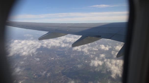 Vista da asa do avião através da janela do avião. Voando acima das nuvens . — Vídeo de Stock