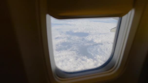 Vista da asa do avião através da janela do avião. Voando acima das nuvens . — Vídeo de Stock