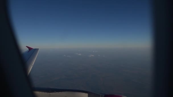 View of flying airplane wing through plane window. — Stock Video