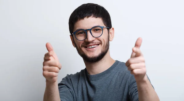 Portrait de jeune homme souriant avec des lunettes sur fond blanc studio pointant avec les doigts à la caméra — Photo