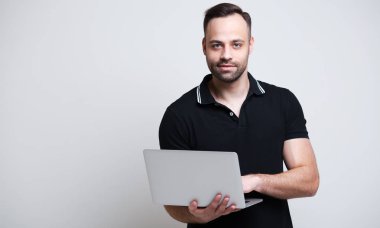 Laptop beyaz arka plan üzerinde elinde tutan genç adam