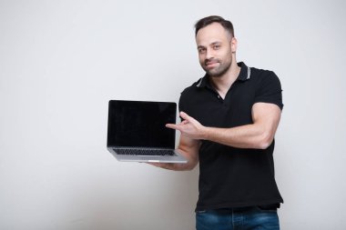 Genç gülümseyen adam üstünde Laptop beyaz arka plan üzerinde işaret