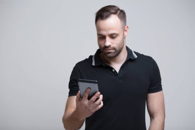 Genç adam holding tablet beyaz arka plan üzerinde