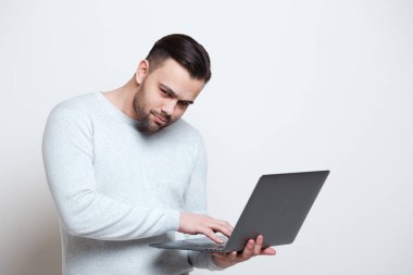 Beyaz arka plan üzerinde tipik dizüstü klavye üzerinde genç adam portresi