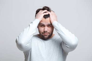 El ile baş beyaz üzerinde tutarak baş ağrısı ile genç adam portresi