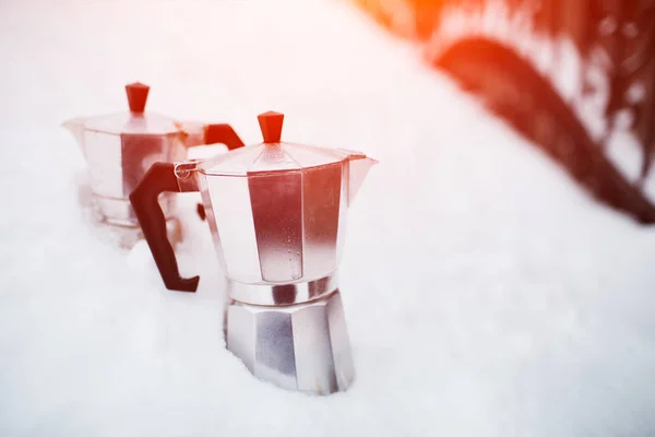Close-up of two coffee moka in snow.